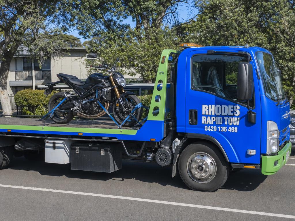 Motorbike strapped to a Rhodes Rapid Tow flatbed truck